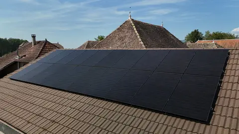 Champ de panneaux photovoltaïques full black posés sur une toiture en tuiles aux Avenières Veyrins-Thuellin (38)