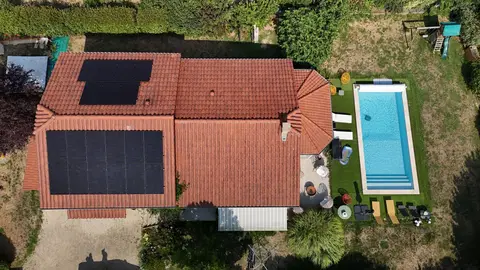 Vue aérienne d'une maison à Maubec (38) équipée d'une installation photovoltaïque de 9,5 kWc répartie sur deux pans de toiture