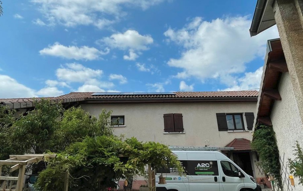 Installation photovoltaïque sur un toit, camion A2C Énergies devant la maison.